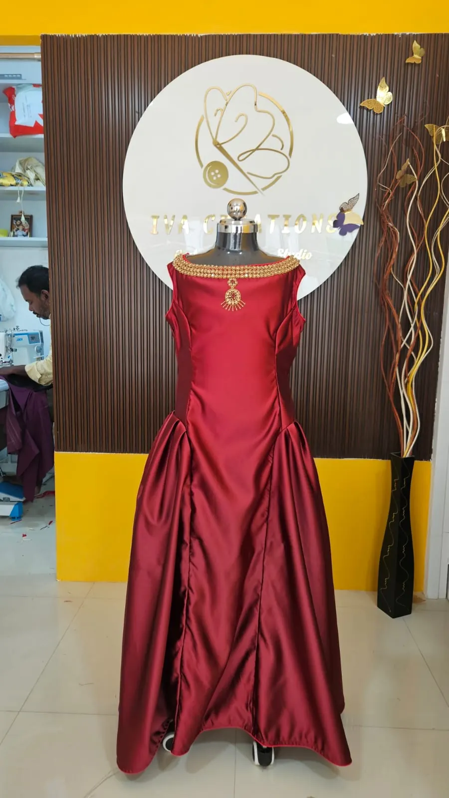Maroon satin gown with a gold jewelled neckline