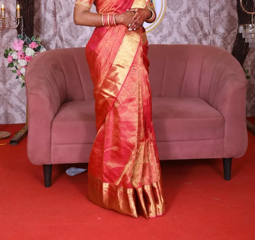 Red and gold silk saree draped with a hand-embroidered blouse